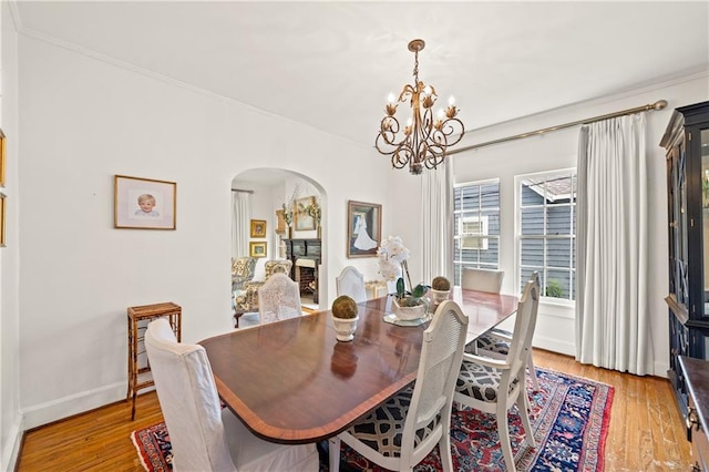 159 Roberts St, Mobile, AL 36604 - dining room featuring arched walkways, a chandelier, light wood-style floors, and crown molding