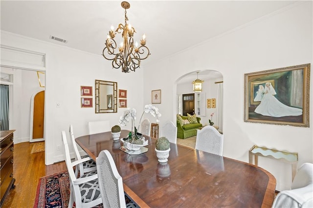 159 Roberts St, Mobile, AL 36604 - dining room with arched walkways, a chandelier, ornamental molding, and dark wood-style floors