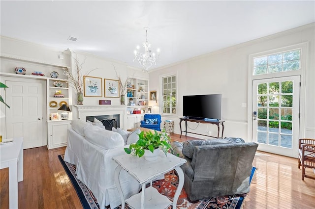 159 Roberts St, Mobile, AL 36604 - living area featuring a chandelier, ornamental molding, wood finished floors, built in shelves, and a fireplace
