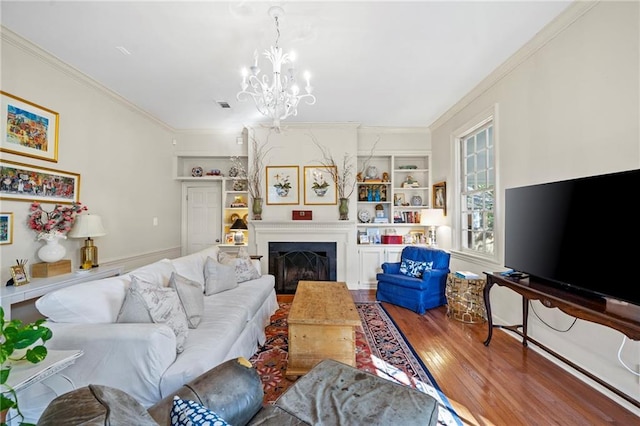 159 Roberts St, Mobile, AL 36604 - living room featuring ornamental molding, wood finished floors, a chandelier, built in shelves, and a fireplace