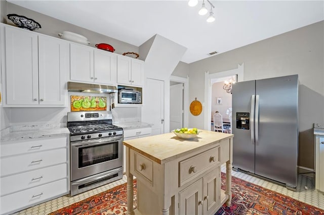 159 Roberts St, Mobile, AL 36604 - kitchen with stainless steel appliances, under cabinet range hood, butcher block countertops, and white cabinetry