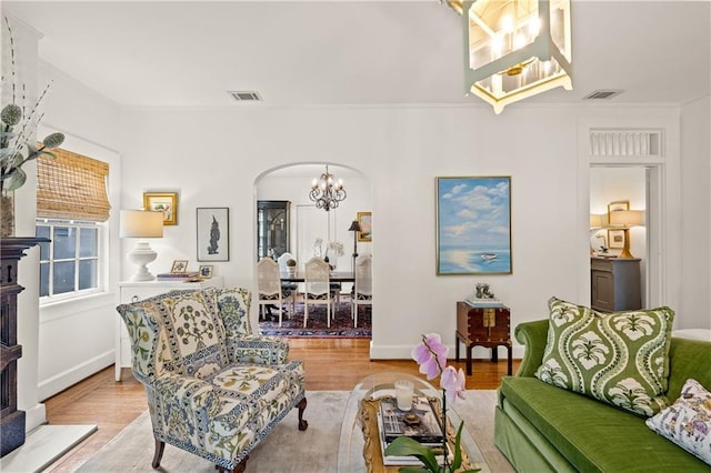 159 Roberts St, Mobile, AL 36604 - living area with a chandelier, arched walkways, crown molding, light wood finished floors, and a fireplace