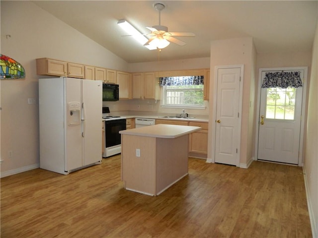 kitchen featuring lofted ceiling, a kitchen island, white appliances, and a wealth of natural light