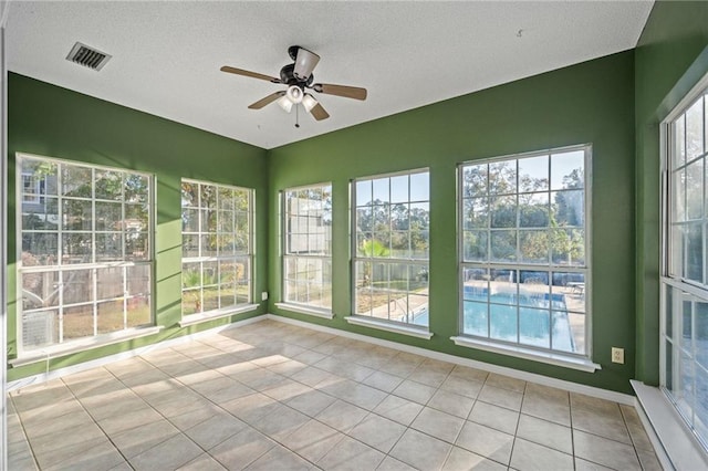 unfurnished sunroom featuring ceiling fan