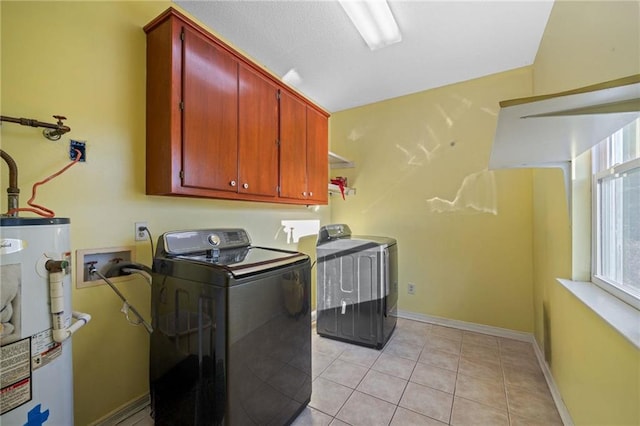 washroom with washer and clothes dryer, light tile patterned flooring, cabinets, and water heater