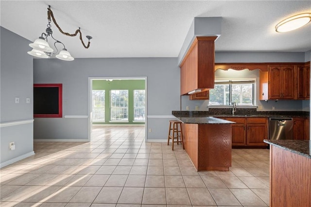 kitchen featuring a kitchen bar, light tile patterned floors, decorative light fixtures, an inviting chandelier, and dishwasher