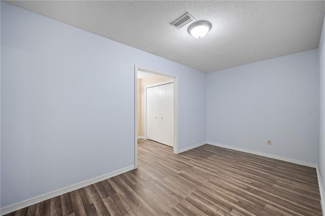 unfurnished room featuring hardwood / wood-style floors and a textured ceiling