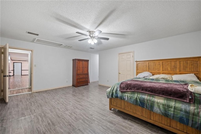 bedroom with ceiling fan, light wood-type flooring, and a textured ceiling