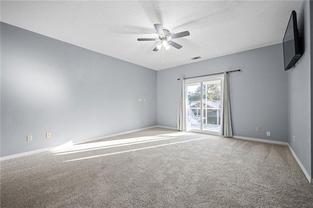 spare room featuring ceiling fan, carpet, and a textured ceiling