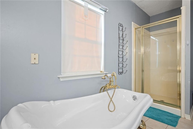 bathroom with tile patterned flooring, separate shower and tub, and a textured ceiling