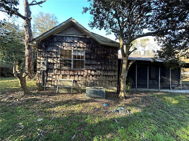 view of property exterior with cooling unit and a sunroom