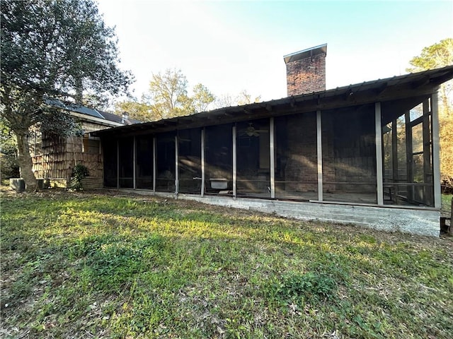 rear view of house featuring a sunroom and a chimney