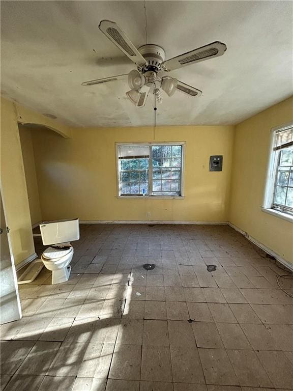 unfurnished room with baseboards and a ceiling fan