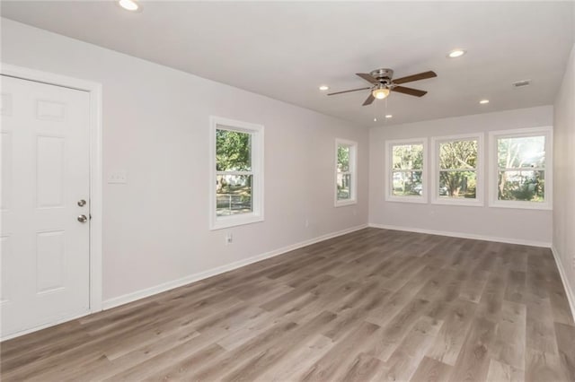 spare room with recessed lighting, baseboards, and wood finished floors