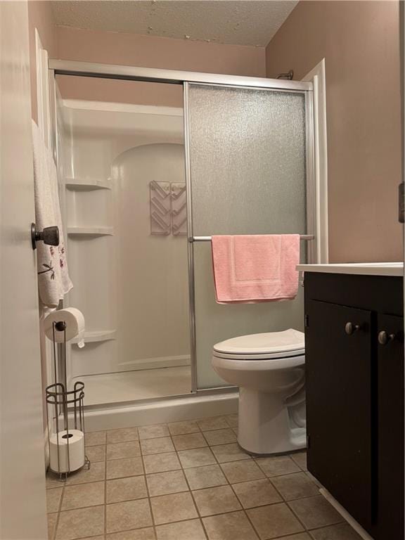 5721 Long Meadow Rd, Mobile, AL 36609 - bathroom featuring tile patterned flooring, a shower stall, vanity, toilet, and a textured ceiling