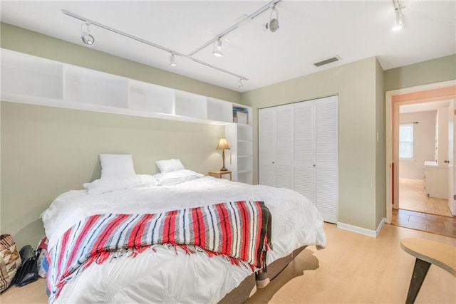 5721 Long Meadow Rd, Mobile, AL 36609 - bedroom with rail lighting, a closet, wood finished floors, and baseboards