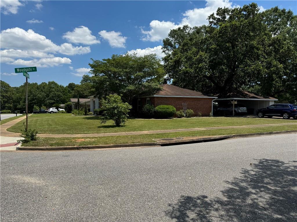 view of front of home with a carport and a front lawn