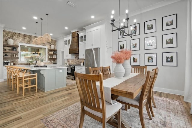 dining space featuring recessed lighting, a notable chandelier, crown molding, and light wood-style floors