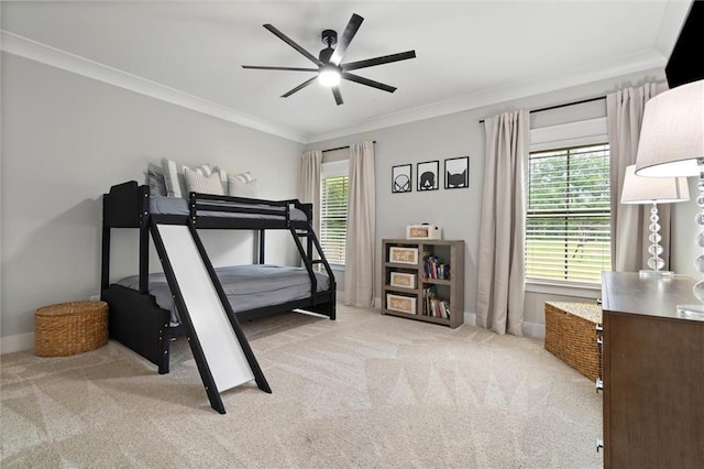 carpeted bedroom featuring baseboards, ornamental molding, and ceiling fan
