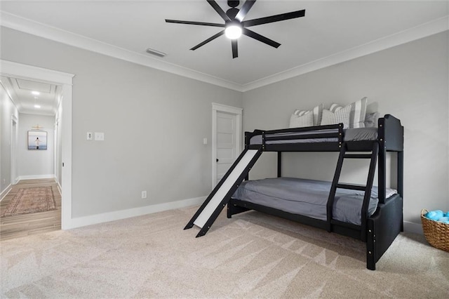 carpeted bedroom featuring crown molding, attic access, baseboards, and visible vents