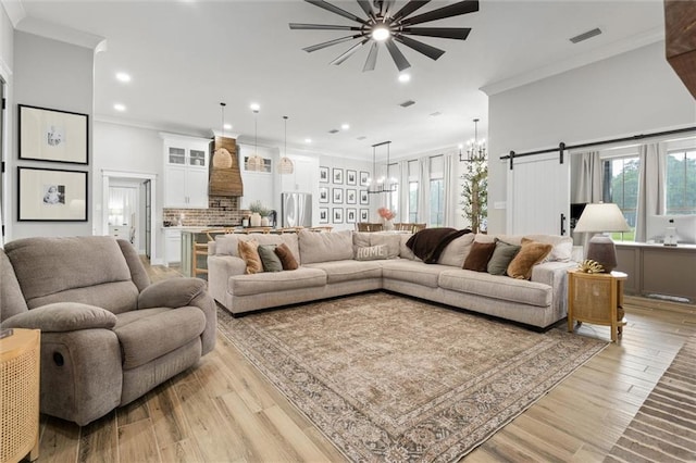 living room with ceiling fan with notable chandelier, visible vents, light wood-style floors, ornamental molding, and recessed lighting