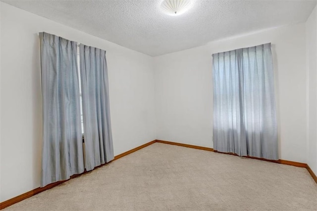 unfurnished room with a textured ceiling and carpet