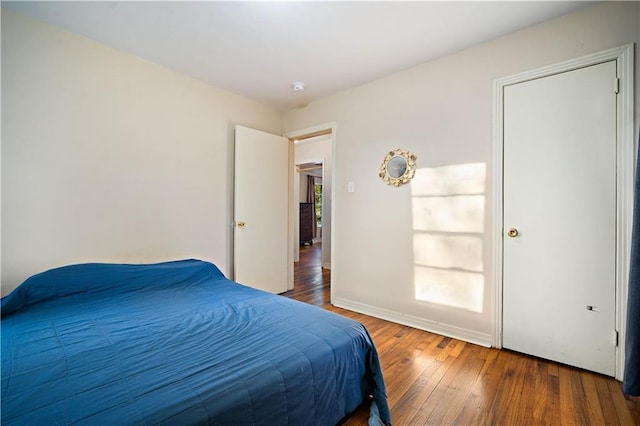 bedroom with hardwood / wood-style flooring, multiple windows, and baseboards