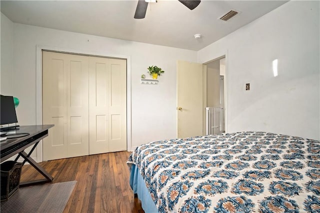 bedroom featuring a closet, dark wood finished floors, visible vents, and a ceiling fan