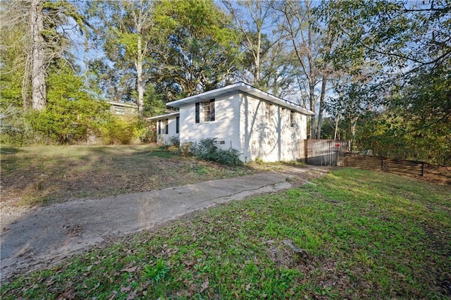 view of home's exterior with fence and a yard