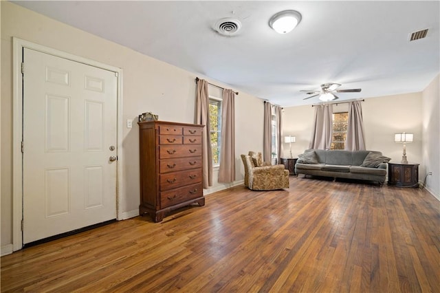 unfurnished living room with a healthy amount of sunlight, visible vents, and hardwood / wood-style floors