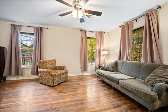 living room featuring plenty of natural light, wood finished floors, visible vents, and baseboards