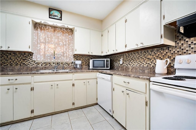 kitchen featuring dark countertops, white appliances, white cabinets, and a sink