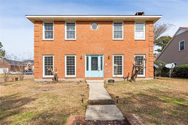 colonial inspired home featuring a front lawn