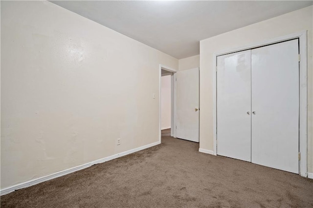 unfurnished bedroom featuring light colored carpet and a closet