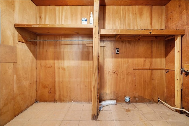 laundry area with wooden walls, tile patterned floors, and electric dryer hookup