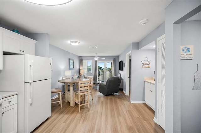 400 Plantation Rd Unit 4206, Gulf Shores, AL 36542 - kitchen featuring freestanding refrigerator, light wood-style flooring, white cabinetry, light countertops, and ceiling fan