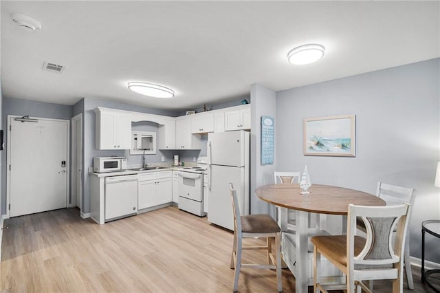 400 Plantation Rd Unit 4206, Gulf Shores, AL 36542 - kitchen with white appliances, white cabinets, light wood-style flooring, a sink, and light countertops