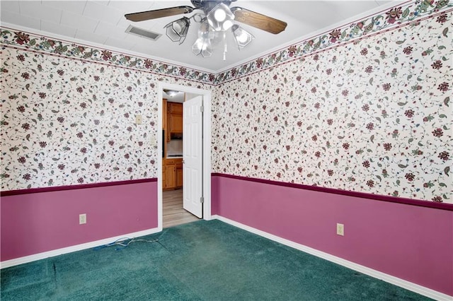 carpeted empty room featuring ceiling fan and crown molding