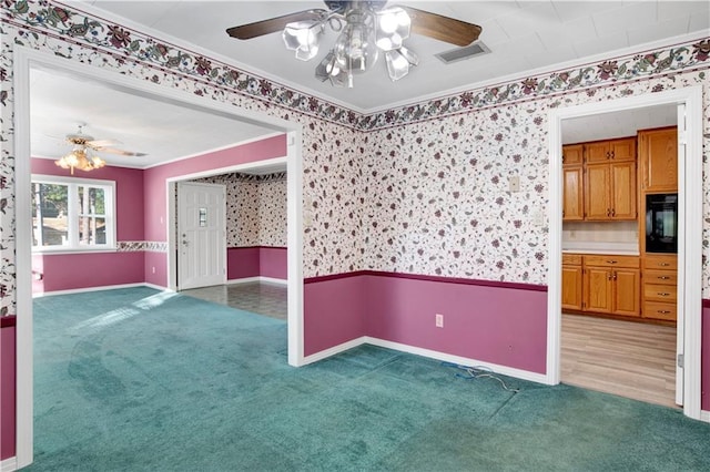 unfurnished room with carpet floors, crown molding, and ceiling fan