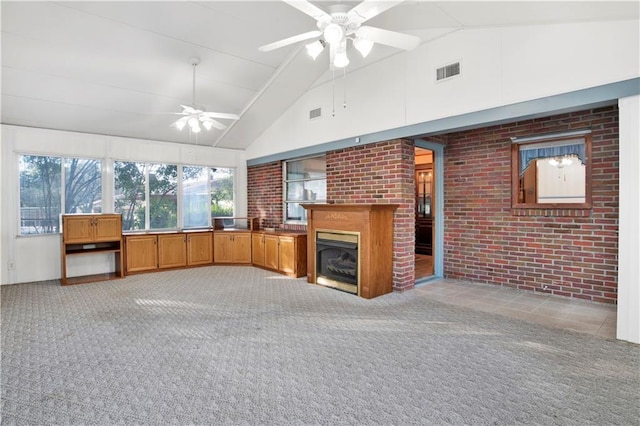 unfurnished living room with ceiling fan, brick wall, high vaulted ceiling, and light carpet