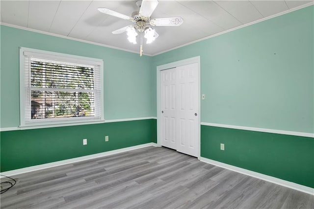 spare room featuring ceiling fan, light hardwood / wood-style floors, and crown molding