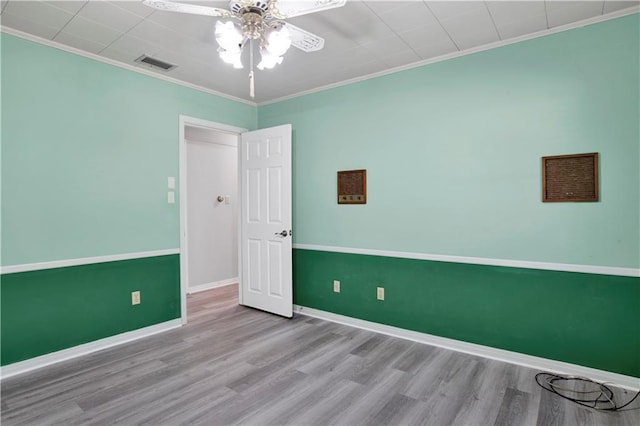 spare room with ceiling fan, ornamental molding, and light hardwood / wood-style flooring