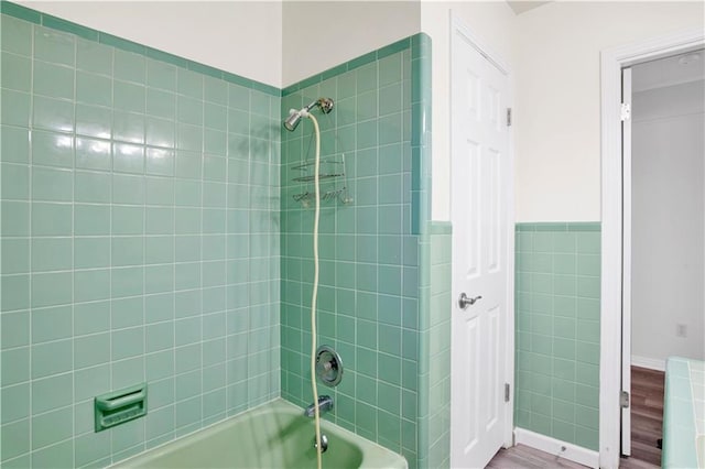 bathroom with tiled shower / bath and hardwood / wood-style floors