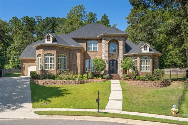 french country home with a garage and a front lawn