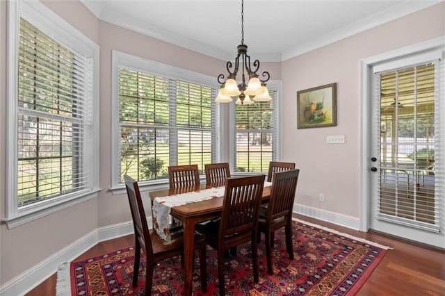 dining space with wood-type flooring, ornamental molding, and a chandelier