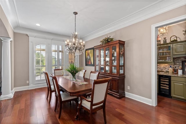 dining area featuring ornate columns, crown molding, and beverage cooler