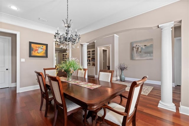 dining room featuring decorative columns, an inviting chandelier, dark hardwood / wood-style floors, and ornamental molding