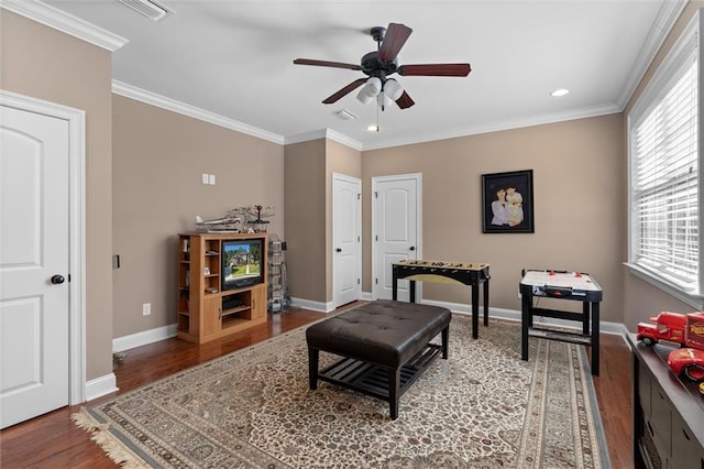 living area with hardwood / wood-style floors, ceiling fan, and ornamental molding