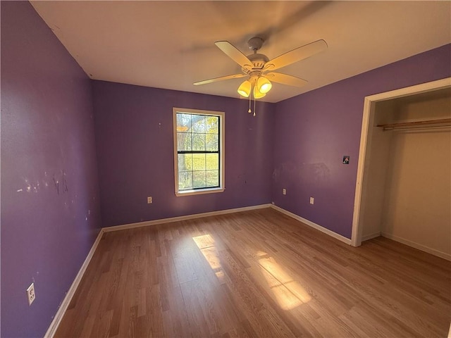 unfurnished bedroom with ceiling fan, a closet, and light wood-type flooring