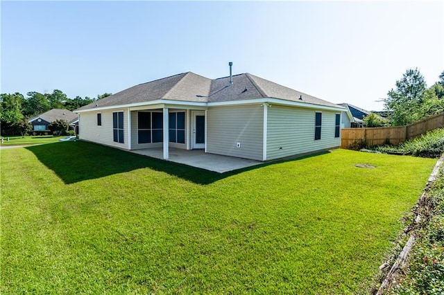 rear view of property featuring a lawn and a patio area